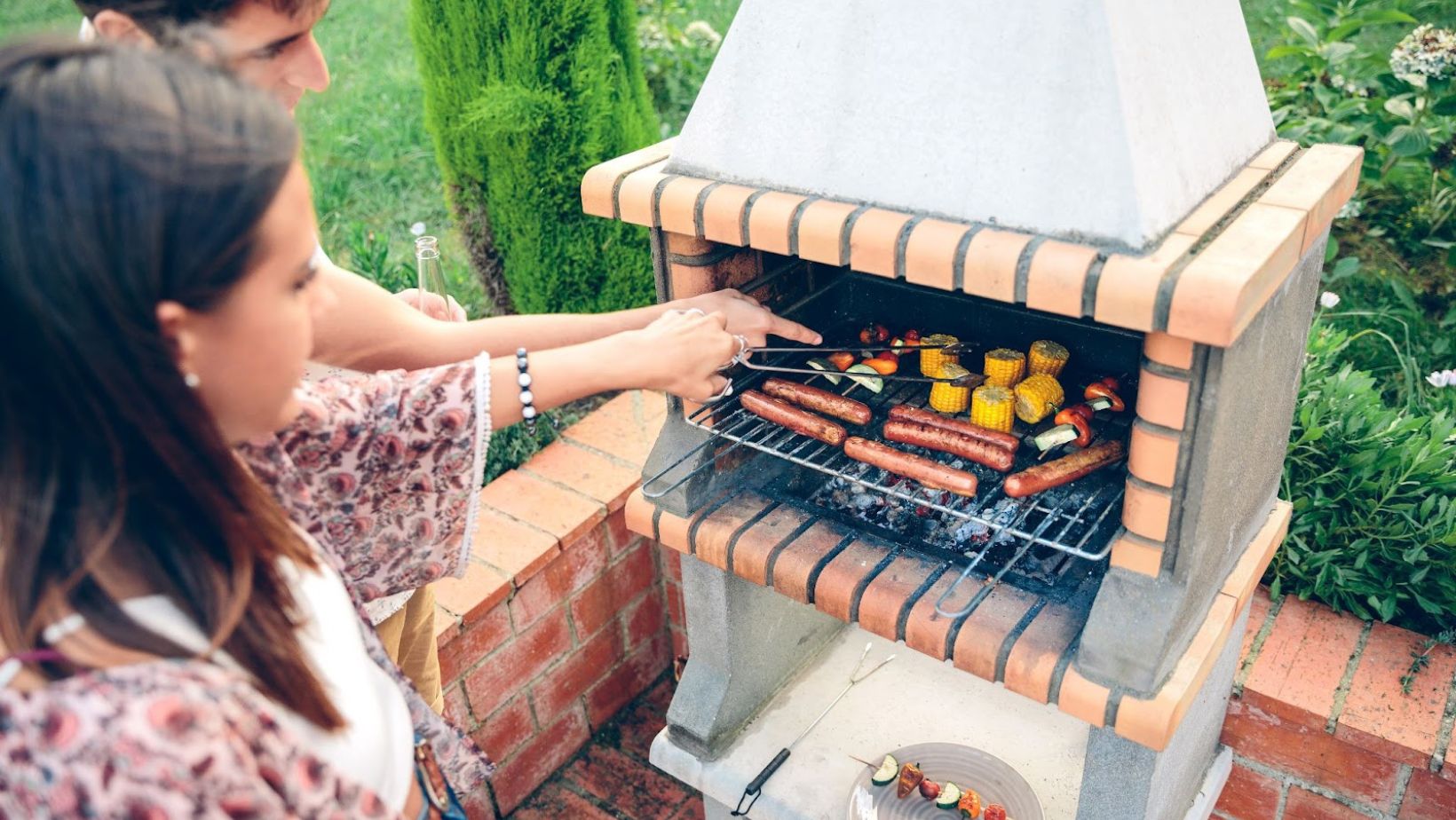 friends using a small brick grill